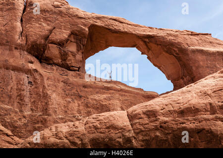 Low angle view of man at Balanced Rock, Arches National Park, Moab, Utah, USA Stock Photo