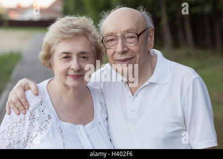 Portrait of smiling senior couple standing at park Stock Photo