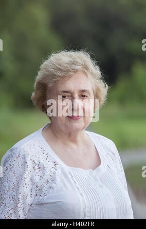 Portrait of beautiful senior woman standing at park Stock Photo