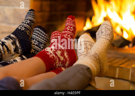 Family in socks near fireplace in winter or christmas time Stock Photo