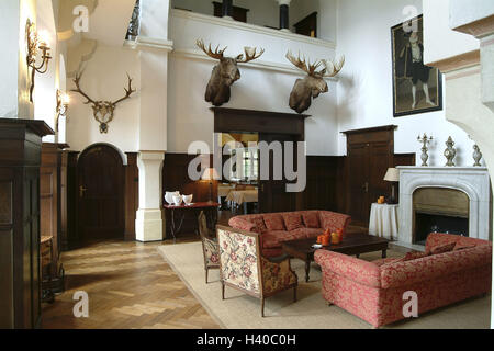 Germany, Saarland, Mettlach, guest house lock Saar corner, foyer, Europe, company Villeroy & Boch, house, building, villa, entrance hall, chimney, seat group, hunting trophies, trophies, animal preparations, preserves, elk's heads, deer antlers, antlers, wall decoration, decoration, setup, living, residential decoration, nobly, elegantly, luxury, luxuriously, only editorially Stock Photo