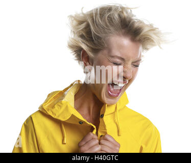 Woman, blond, shout, portrait, rain jacket, wind young, eyes closed, short-haired, blown hair, windswept hair, rain clothing, rain protection, facial play, shriek, hysterically, furiously, aggressively, shout, fury, rage, windy, stormily, chilly, gust win Stock Photo