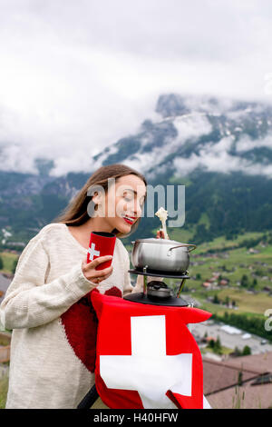 Woman with fondue in the mountains Stock Photo