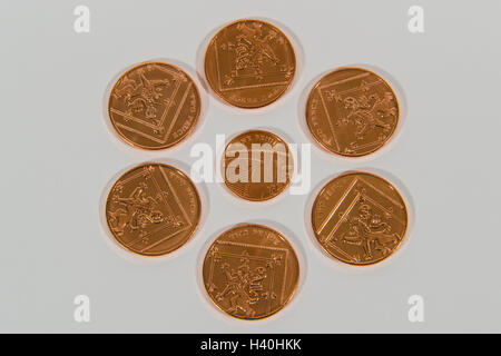 Close-up detail of money - current UK sterling, copper coins, in 2 denominations,   with 2p pieces around a single 1p piece. Stock Photo