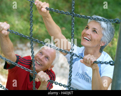 keep-fit trail, Senior couple, climbing frame, climb, smile, happy, 50-60 years, 60-70 years, couple, senior citizens, man, woman, Best Age, sportily, sport, activity, health, fitness, activity, training, catenas, scaffolding, fun, together, motion, skill Stock Photo