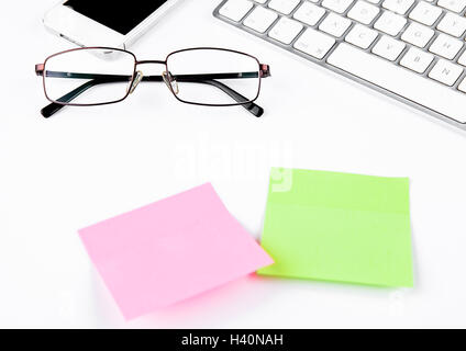 White keyboard with glasses and sticky note papers on white background Stock Photo