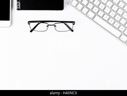 White keyboard with glasses and phone with notepad on white background Stock Photo
