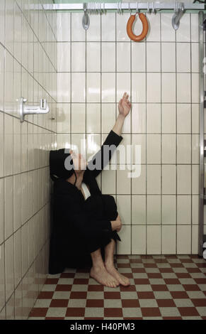 Chill house, man, suit, cap, sit, reach floor, barefoot, wall, harbour, sausage, gesture, slaughter-house, tiled, squatted, 30-40 years, desperation, helplessness, desolation, hopelessly, hopelessness, hunger, feebly, pork sausage, inaccessibly, survival Stock Photo