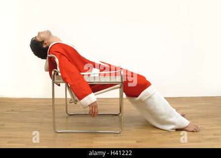 Santa Claus, exhausts, chair, sit, side view, man, person, young, 20-30 years, dark-haired, Christmas, Christmas, yule tide, for Christmas, Christmas, xmas, x-mas, feast, feasts, holidays, Christmas Days, casing, red, costume, dresses up, lining, panelled Stock Photo