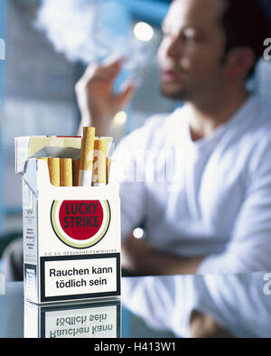 Cigarette box, EU-warning tip, background, man, cigarette, smoke, blur cigarettes, filtertip cigarettes, box, cigarette packet, mark, cigarette mark, producer, Lucky Strike, cigarettes-warning tip, warning tip, warning, cigarette label, label, print, refreshing, EU regulation, order, duty to inform, information, customer's information, deterrence, health, health risk, clarification, attention, smoker, 28 years, consumption, enjoy, mania, nicotine mania, recreation, ignore, 20-30 years, no property release, Stock Photo