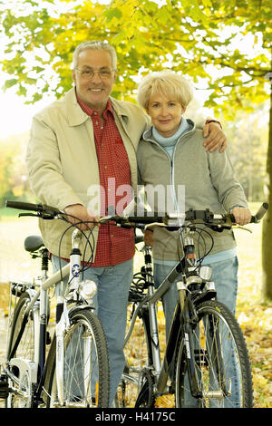 Forest way, Senior couple, smile, push away bicycles, senior citizens, embrace, arm in arm, affection, Best Age, leisurewear, leisure time, fitness, fit, agile, initiative, together, sport, sportily, motion, activity, cycle prompt, wood, autumn, season, a