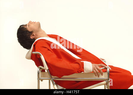 Santa Claus, exhausts, chair, sit, side view, man, person, young, 20-30 years, dark-haired, Christmas, Christmas, yule tide, for Christmas, Christmas, xmas, x-mas, feast, feasts, holidays, Christmas Days, casing, red, costume, dresses up, lining, panelled Stock Photo