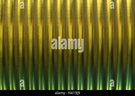 Abstract image of metal / tin can strengthening ridges (actually a baked bean tin) illuminated with yellow-green colored light. Abstract steel can. Stock Photo