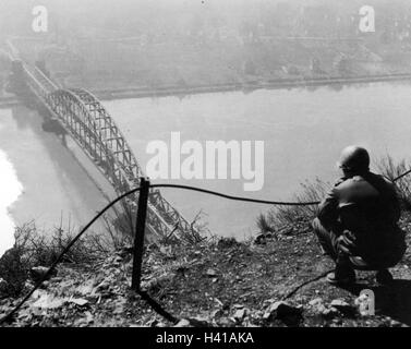 REMAGEN BRIDGE (aka Ludendorff Bridge) over the Rhine after it's capture by a task force of the US 9th Armourd Division on 7 March 1945. Photo taken 9 March from the Erpeler Ley shows Dan Feltner of the 656 Tank Destroyer Battalion checking the view. Photo US Army Signal Corps. Stock Photo