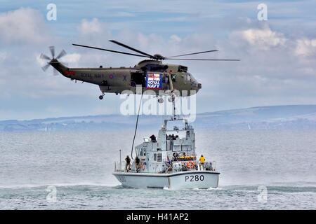 A Royal Navy Sea King Mk7 helicopter demonstrating troops boarding a pirate ship at Bournemouth Air Festival. Stock Photo