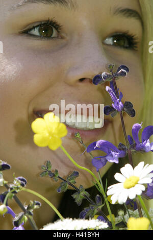 Flower meadow, teenager's girl, happy, look, meadow flowers, detail, spring, leisure time, young persons, girls, teenagers, 15 years, blond, colour eyes brown, naturalness, beauty, attraction, smile, smell course, happy, cheerfully, transmission, positive Stock Photo