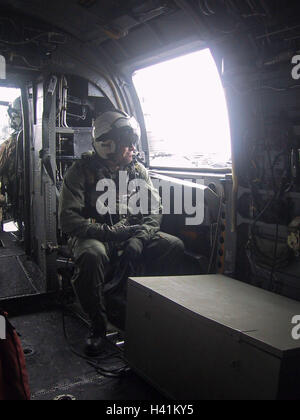 28th January 2003 During Operation Enduring Freedom, a naval aircrewman sits at the side door of a U.S. Navy Sea Knight helicopter. Stock Photo