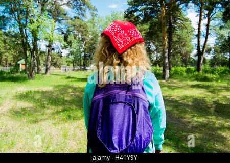 Woman wearing bandana carrying backpack in park Stock Photo