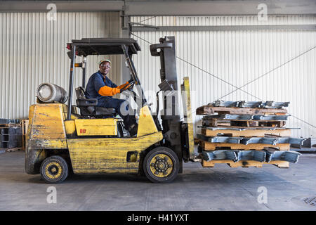 Black worker driving forklift in factory Stock Photo