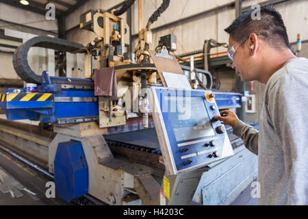 Asian worker using control panel in factory Stock Photo