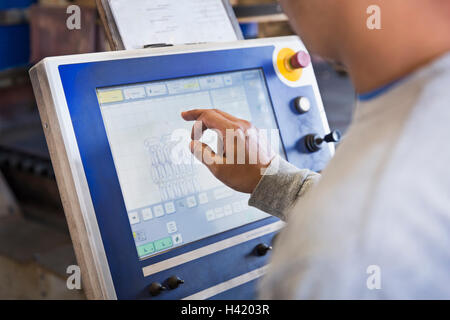 Asian worker using control panel in factory Stock Photo