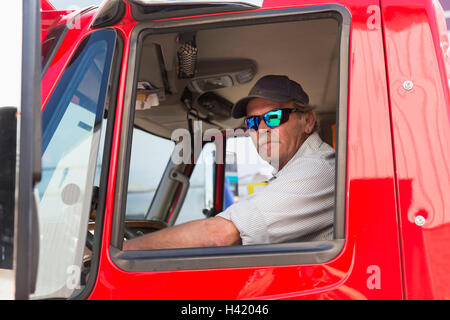 Serious Caucasian semi-truck driver wearing sunglasses Stock Photo
