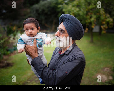 Indian grandfather holding baby grandson Stock Photo