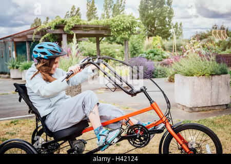 Caucasian woman riding tricycle Stock Photo