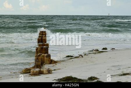 Heavy waves rolling in on old cement pillars. Stock Photo