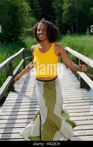 Woman, laugh young, dark-skinned, bridge, happy, non-whites, curls, dark-haired, summer, the sun, enjoy, leisure time, vacation, funnily, joy life, fun, joy, carefree, casually, exhilarates, motion, go, summer clothes, top, tank top, summery, yellow, rock, melted, youth, amuse, happy, liveliness, vitality, impulsively, positively, mood, transmission, naturalness, outside, wooden jetty, nature, lifestyle, Stock Photo