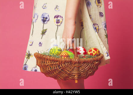 Easter, girls, Easter nest, carries,  close-up  Easter, Eastertime, child, 8 years, childhood, Flechtkorb,, Basket, Easter eggs, colorfully, colorfully, paints, surprise, gift, Easter gift, broached, Background red Stock Photo