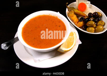Red Lentil Soup served with mixed olives and lemon Stock Photo