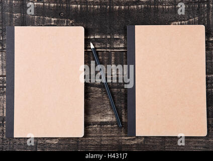 Two blank brown notebooks with black pencil on office desk Stock Photo