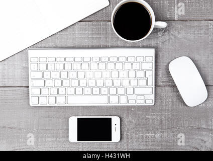 Keyboard with phone coffee cup and mouse on office desk Stock Photo