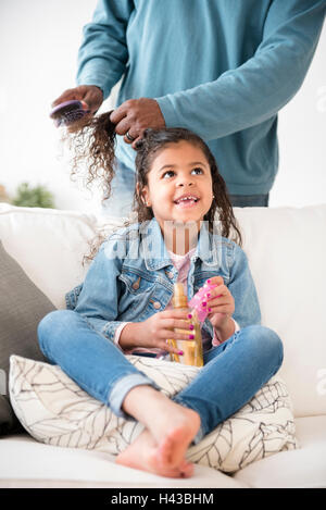 Father brushing hair of daughter Stock Photo