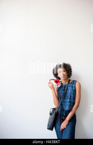 Black woman carrying purse holding headphones Stock Photo