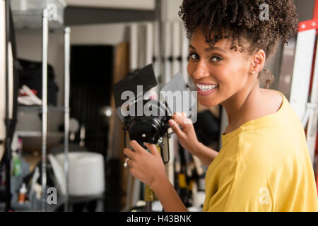 Black photographer adjusting lamp in studio Stock Photo