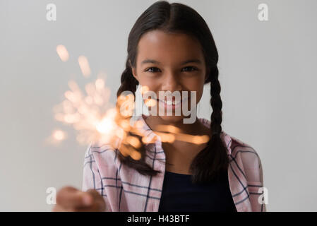 Mixed Race girl holding sparkler Stock Photo