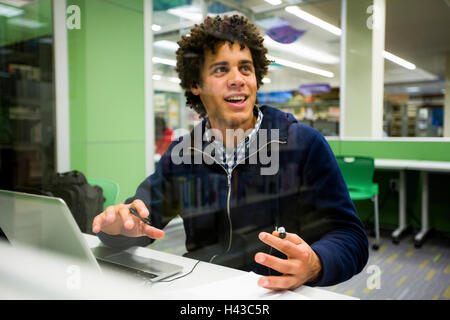 Mixed Race student using laptop in library Stock Photo