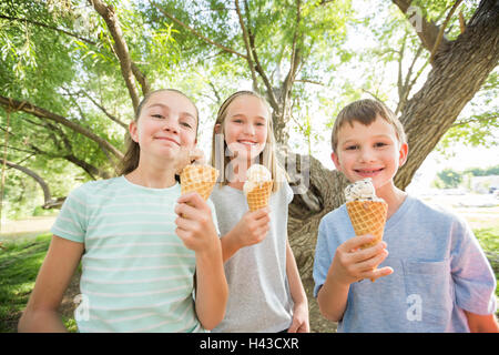Caucasian boy and girls eating ice cream cones Stock Photo