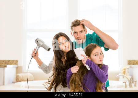 Family grooming hair in bathroom Stock Photo