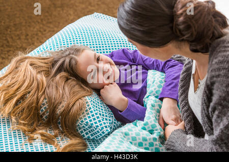 Mother comforting daughter at bedtime Stock Photo