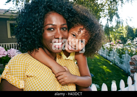 Mother and daughter hugging on spring blossom field. Mom with a child
