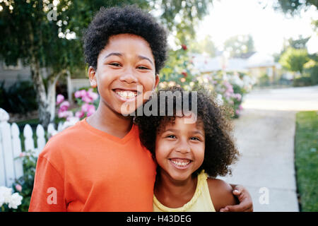 Smiling Mixed Race brother and sister hugging outdoors Stock Photo