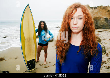 Serious women holding surfboards at beach Stock Photo