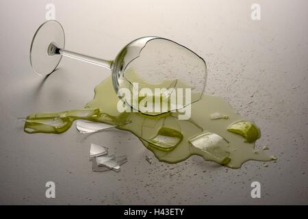 Broken wine glass on white surface. Stock Photo