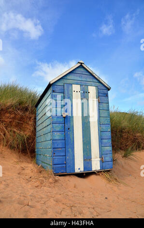 A blue and white striped coloured beach hut on the sands at Elie , Fife. Stock Photo