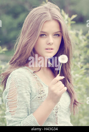 Teenage girl holding a dandelion clock Stock Photo