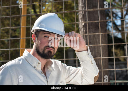 Portrait of an engineer putting on a hard hat Stock Photo