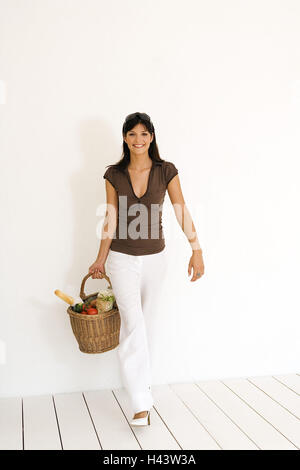 Woman, young, purchasing, basket, smiles, view camera, Stock Photo